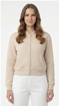 Woman wearing a beige zip-up hoodie on a white background